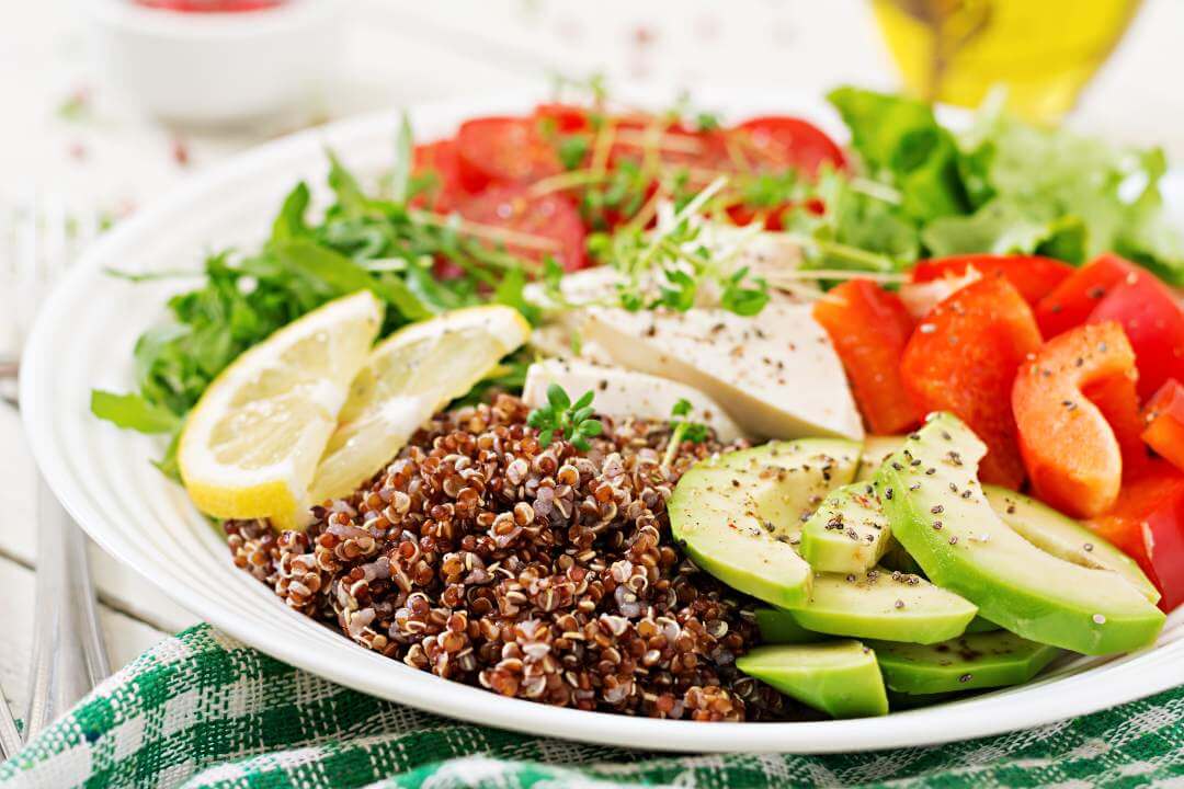 Buddha bowl with quinoa, tofu, avocado, tomatoes and fresh greens
