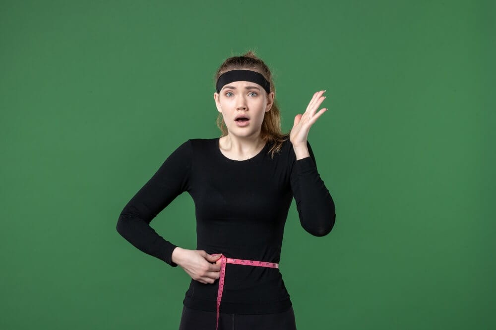 Woman shocked while measuring her waist.