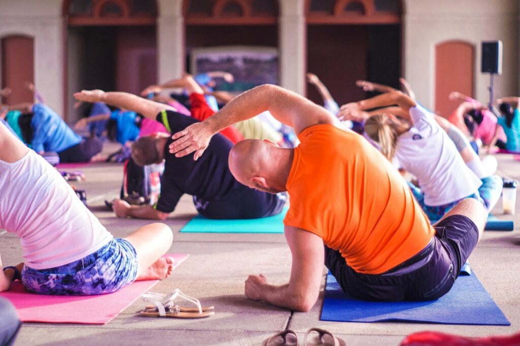 Group of people stretching on colorful mats during a fitness class
