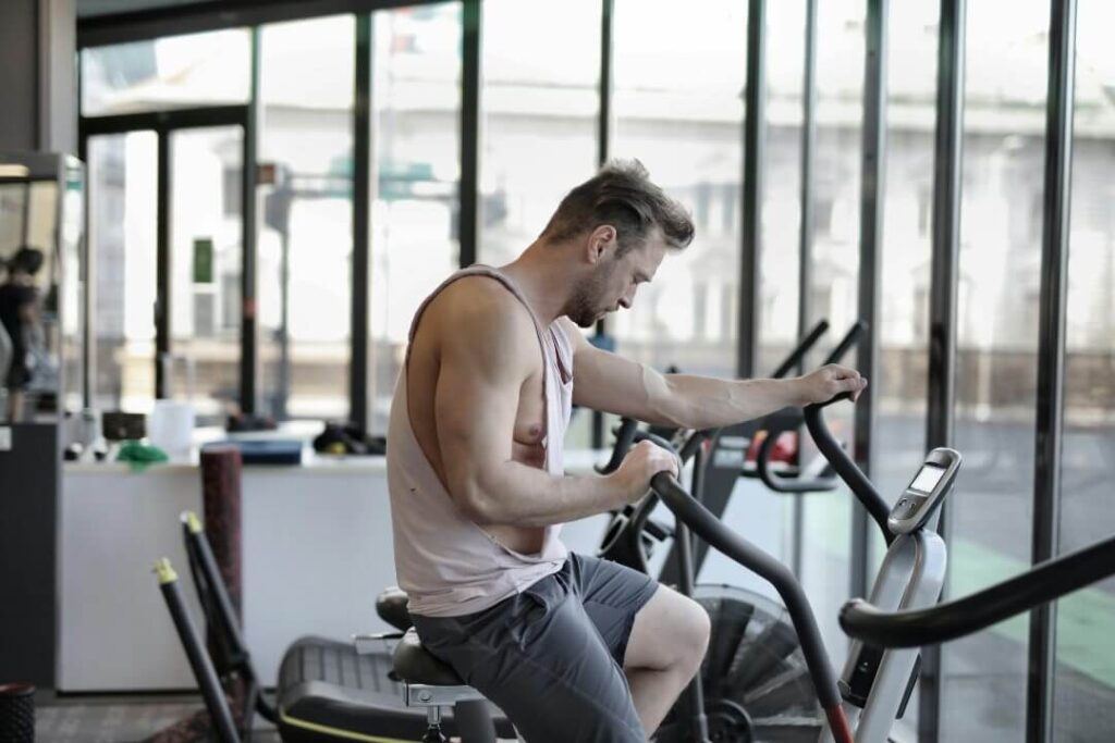 Man doing cardio on bike in gym.