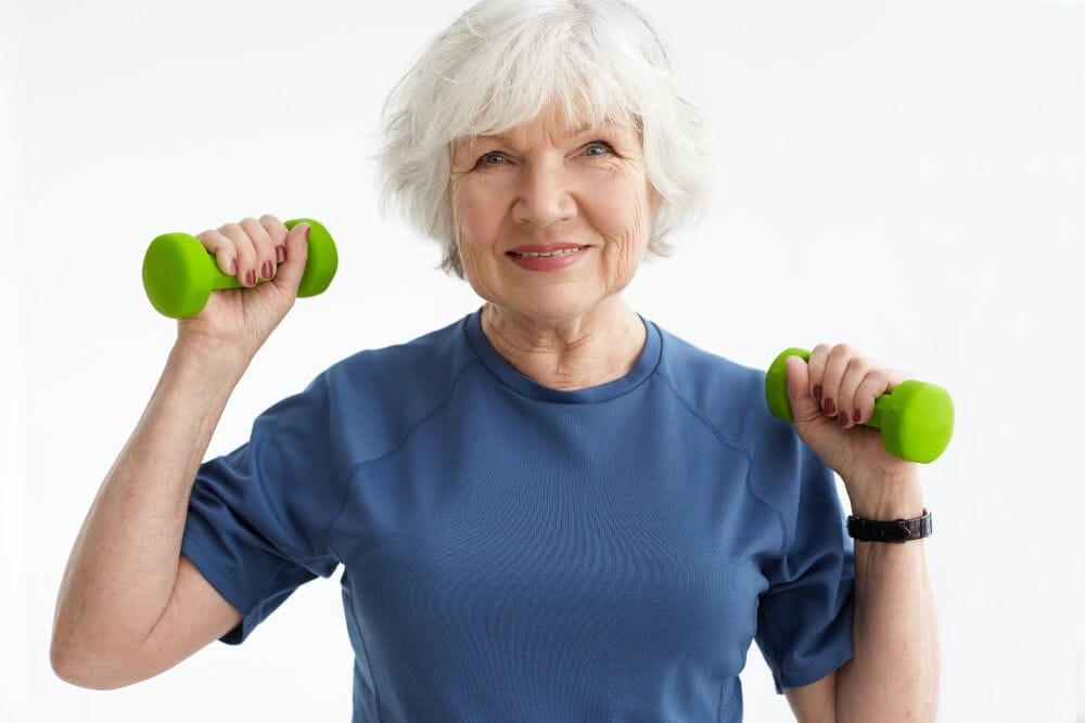 Older woman holding dumbbells.