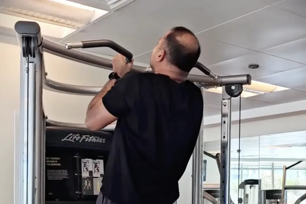 Jeffie performing pull ups on a gym machine
