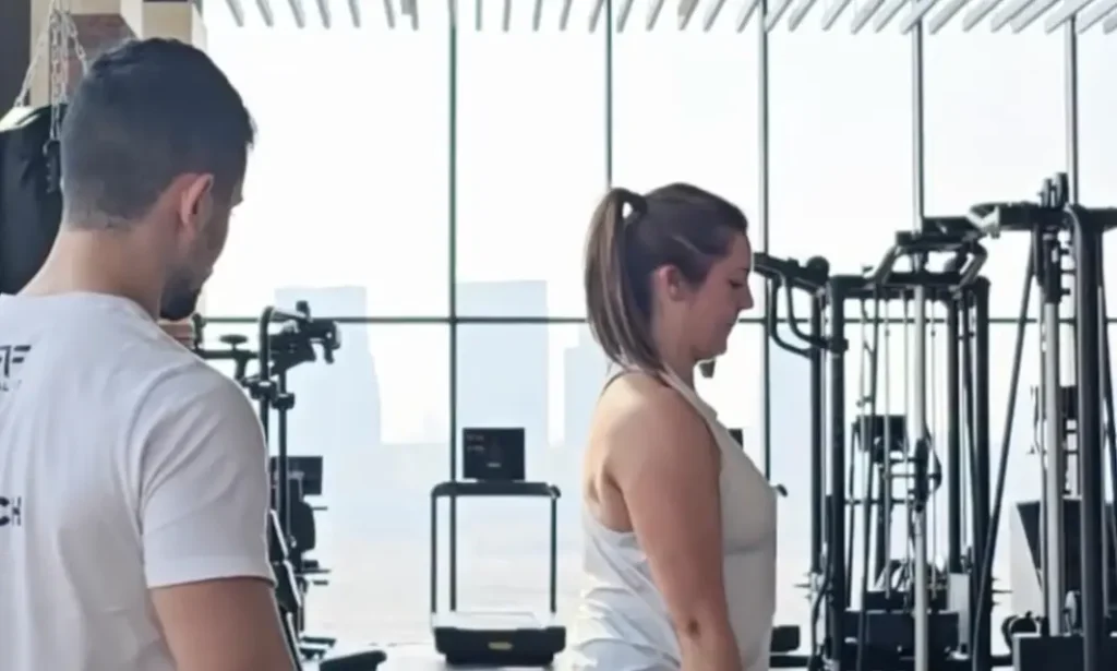 Nadine training in a gym with her Real Fit trainer beside her