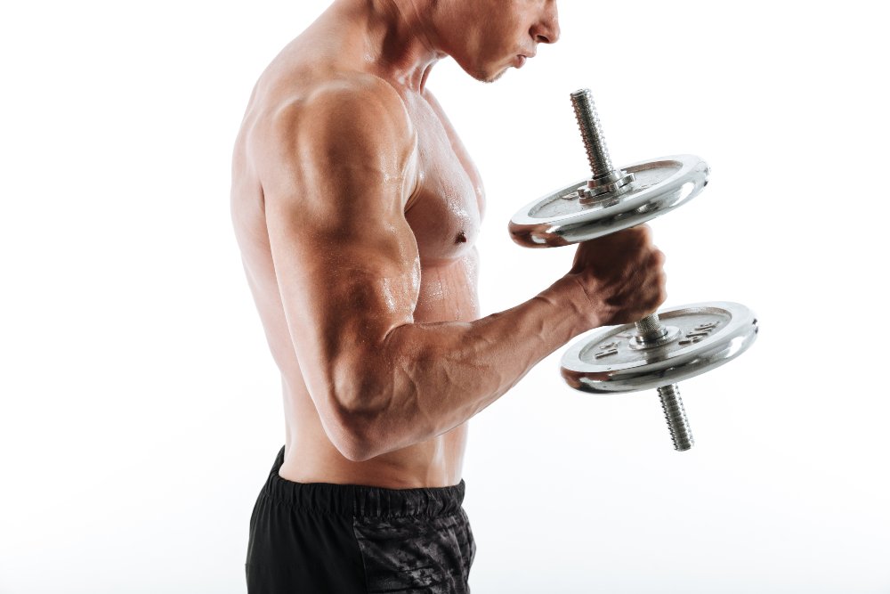 Muscular man lifting a dumbbell, isolated on a white background