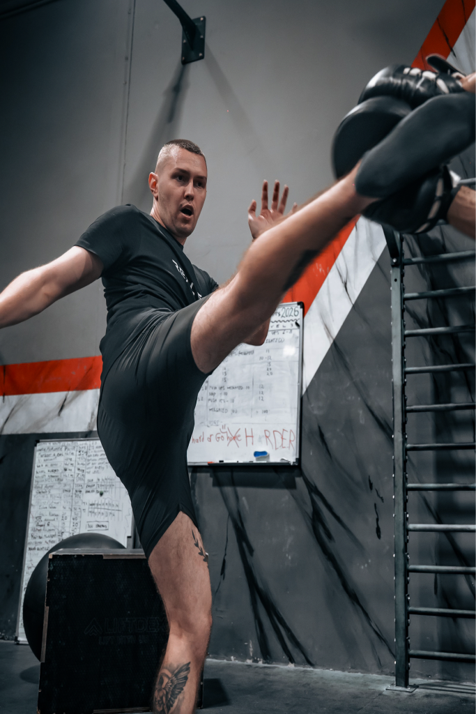 Real Fit trainer kicking pads during a kickboxing session in Abu Dhabi