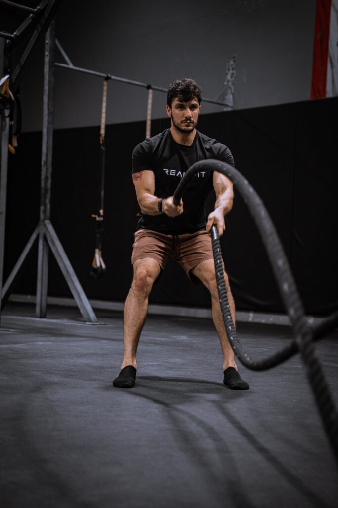 Man training with battle ropes in the gym for weight loss in Abu Dhabi