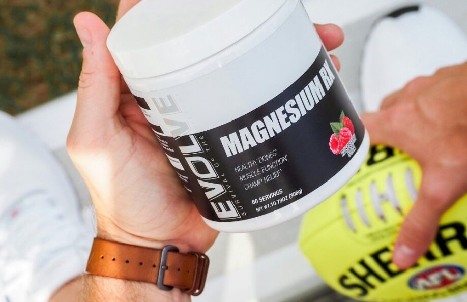Hands holding a tub of magnesium supplement powder