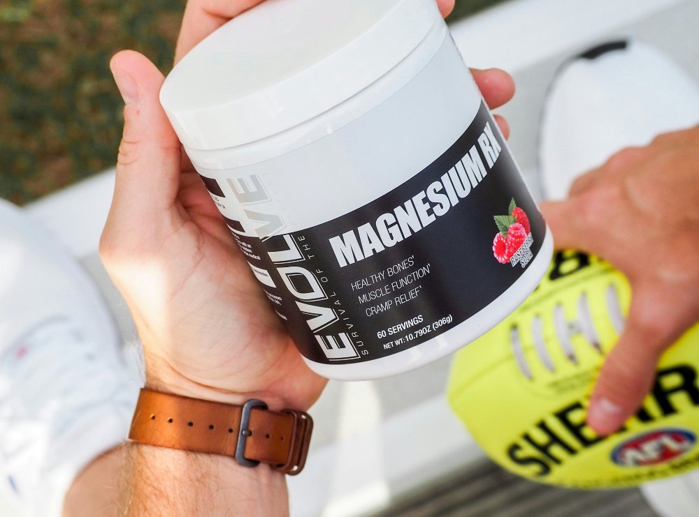 Hands holding a tub of magnesium supplement powder